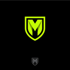 Poster - M letter in a shield. M origami monogram consist of green ribbon. Web, UI icon, isolated on a dark background.