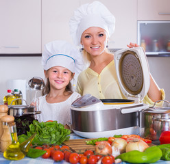 Wall Mural - Housewife and daughter with crockpot at kitchen.