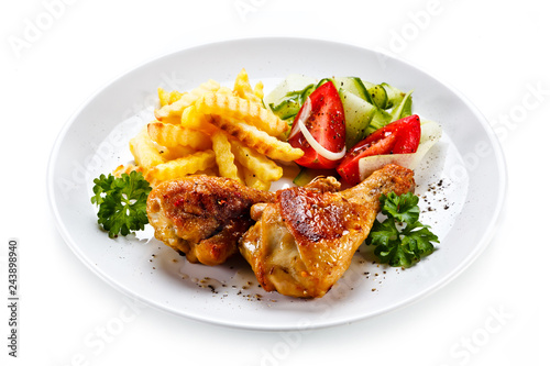Fototapeta na szkło Drumsticks with french fries and vegetable on white background