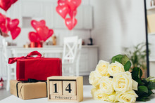 Gift Boxes With Ribbons, Roses Bouquet And Calendar With St Valentine Day Date On Table With Heart-shaped Balloons On Background
