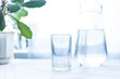 glass cup and carafe with water on a white table