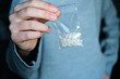 hand holds packet with white narcotic - cocaine, meth or another drug