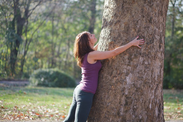 woman hugging a tree in the park