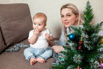 happy mother and her little daughter decorate the Christmas tree