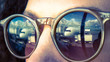 Passenger aircraft reflected in woman's sunglasses at the airport, cross processed vintage effect.