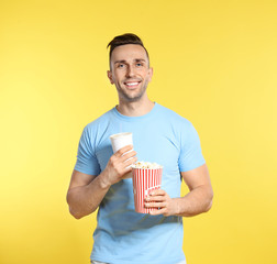 Poster - Man with popcorn and beverage during cinema show on color background