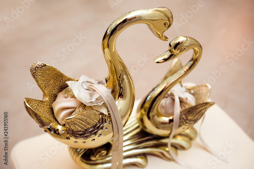 Platinum Wedding Rings On Gold Plate With Couple Swans In