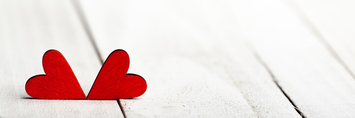Wall Mural - two red valentine's hearts laying on white wooden table