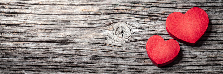 Wall Mural - two red valentine's day hearts on weathered wooden table