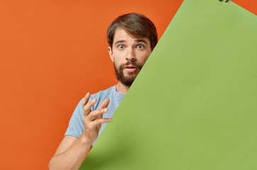 man surprised with a beard holds green background