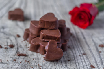 Bombones de chocolate en forma de corazón con flor roja