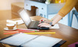 © Lek - Young business woman working in office with laptop on wooden table