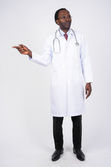 Wall Mural - Full body shot of African man doctor thinking while pointing to the side