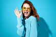 © SHOTPRIME STUDIO - marks with fingers woman joyful in glasses on blue background