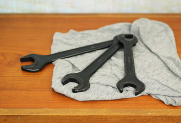 two wrenches arranged on the wooden table in the workroom useful for background