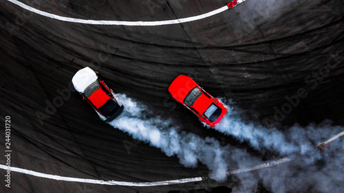 Fotomural Car drift battle on abstract black texture and background tire skid mark, Two car drifting battle on race track with smoke, Aerial view automobile and automotive
