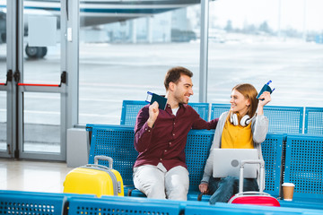 Wall Mural - boyfriend and girlfriend holding passports and looking at each other in airport