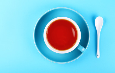 Wall Mural - Blue cup of black red tea over blue background