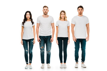 full length view of serious young men and women in white t-shirts and denim pants standing and looki
