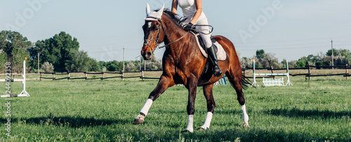 Cuadros en Lienzo A woman jockey rides a horse in a competition in jumping.