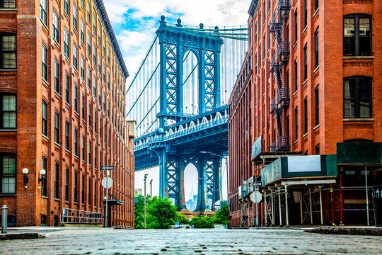 manhattan bridge between manhattan and brooklyn over east river seen from a narrow alley enclosed by
