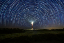 Lighthouse At Night With Star Trails At The Center