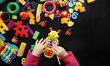 © dyageleva - child is playing with bright toys on a black background