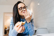 © mnelen.com - happy young brunette student wearing glasses at a cafe after classes and lectures