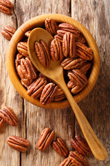 Poster - Raw pecan nuts in a bowl close-up. Vertical top view