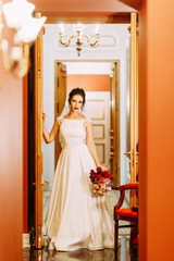 Wall Mural - The bride in an expensive luxury hotel with a bouquet. Standing on the stairs and in the hallway.