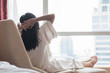 © Chinnapong - Easy lifestyle Asian woman waking up in the morning taking some rest relaxing in cozy hotel room