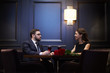 © pressmaster - Young romantic dates sitting by table opposite one another while enjoying talk by dinner in restaurant