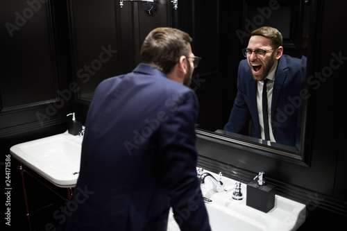 Young Well Dressed Man Bending Over Sink In Front Of Mirror