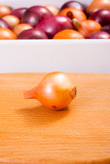 Wall Mural - onions on white wood tray, wooden table background