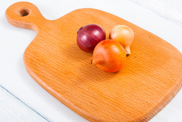 Wall Mural - onions on white wood tray, wooden table background