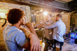Man stopping his friend to get in a bar fight. Group of man drinking in a bar and fighting.