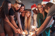 © standret - Party with friends. Group of cheerful young people carrying sparklers and champagne flutes