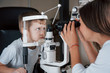 © standret - Little boy having test for his eyes with special optical apparatus by female doctor