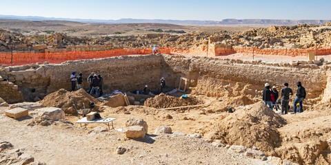 an archaeological dig at shivta national park in israel showing archaeologists and workers excavating the ruins of the water pools