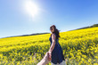 © hiv360 - Girl in a blue dress leaves in a field of rapeseed. Follow me concept