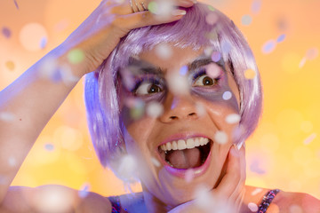 Carnaval Brazil. Face of brazilian woman with violet wig and make up mask. Colorful background. Carnival concept, fun and party.