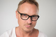© Viktor Koldunov - Male blogger wears spectacles and white t-shirt, looks confidently