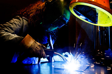 Woman welding in the metal industry