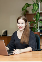 Executive manager at the desk with laptop on table surface, woman at work