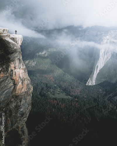 Photo Man standing at edge of cliff over Yosemite Valley, California, USA