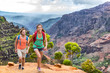 © Maridav - Young happy hikers people walking on Hawaii Waimea Canyon Trail, Kauai island, USA. Asian woman and man couple trekkng in scenic mountain background. Hiking adventure in nature.