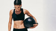 © Jacob Lund - Smiling fitness woman standing with a medicine