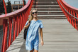 beautiful girl in a blue dress posing on the bridge