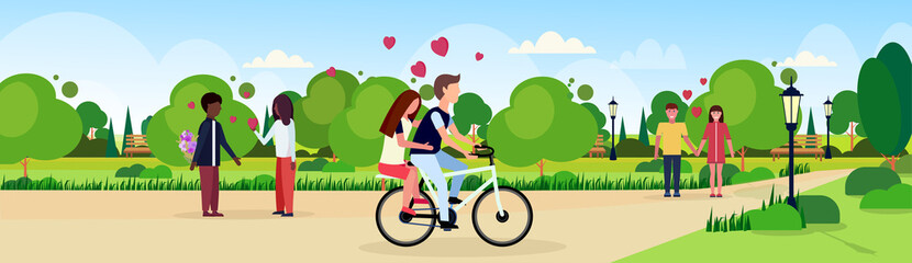 Wall Mural - couples in love riding bicycle walking celebrating happy valentines day holiday concept mix race men women lovers in city urban park landscape background flat horizontal