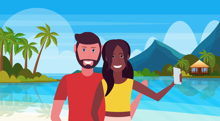 Wall Mural - mix race couple taking selfie photo lovers on tropical beach water bungalow house landscape summer travel vacation honeymoon concept man woman in love full length horizontal flat